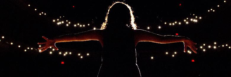 performer silhouetted against lights in Musco Center